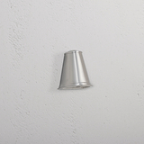 Southwark Mastlamp - Gepolijst Nikkel kleine wandlamp met glanzende metalen afwerking aan witte muur.