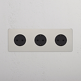 3x Rond Schuko Type F Stopcontact in Drievoudige Afdekplaat, Gepolijst Nikkel met zwart inzetstuk op witte muur.