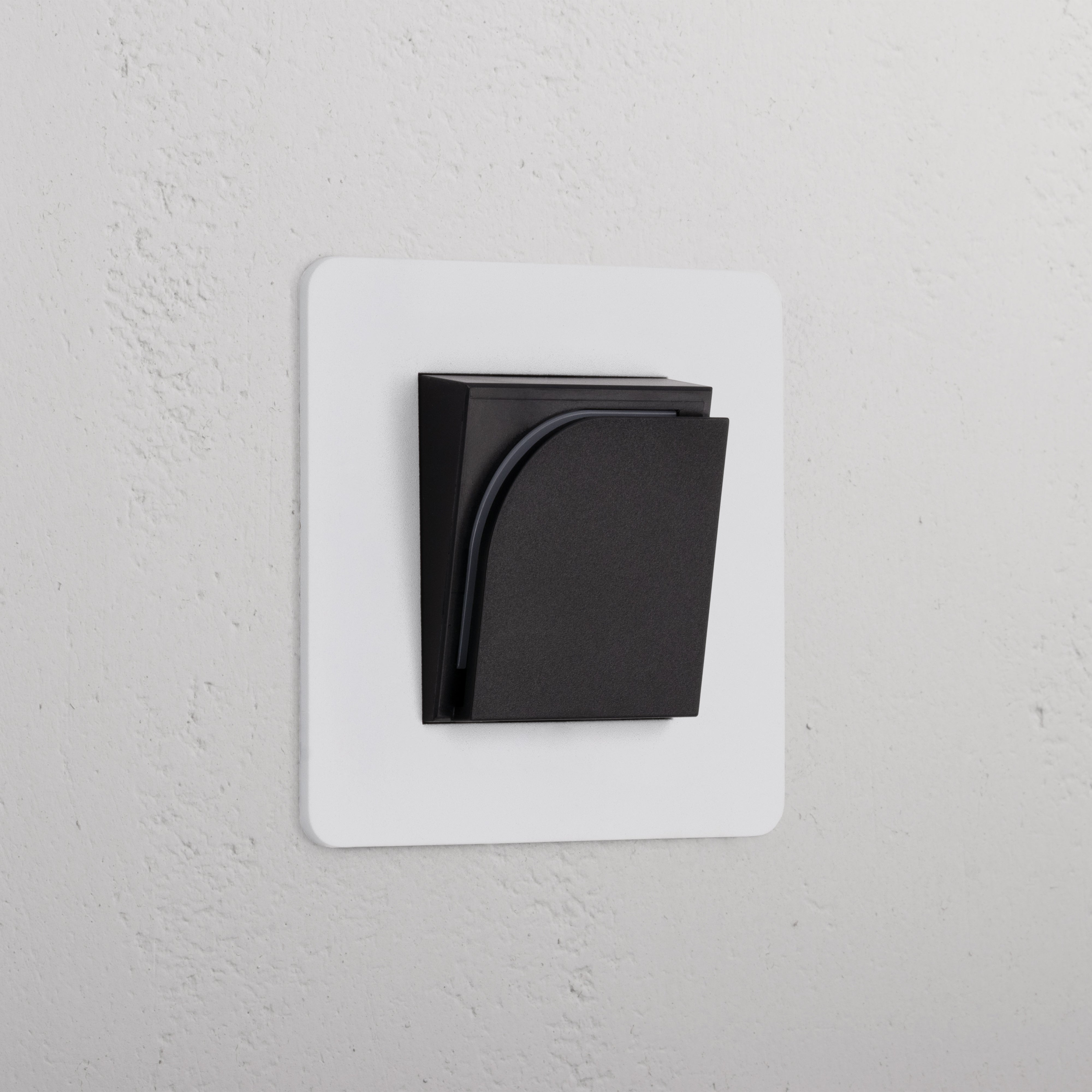 Enkele Hotelkaartschakelaar - Beschilderbaar Zwart, een enkele stopcontactmodule, op een witte gestructureerde muur.