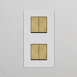 4x Wissel-Wipschakelaar (Dubbele Verticale Afdekplaat) in Beschilderbaar Antiek Messing Wit op een witte muur.