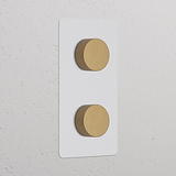 2x Dimmer met dubbele verticale schakelaars in Beschilderbaar Antiek Messing afwerking op een witte rechthoekige basis.