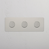 Drievoudige afdekplaat met drie multicontrol dimschakelaars in gepolijst nikkel, horizontaal geplaatst.