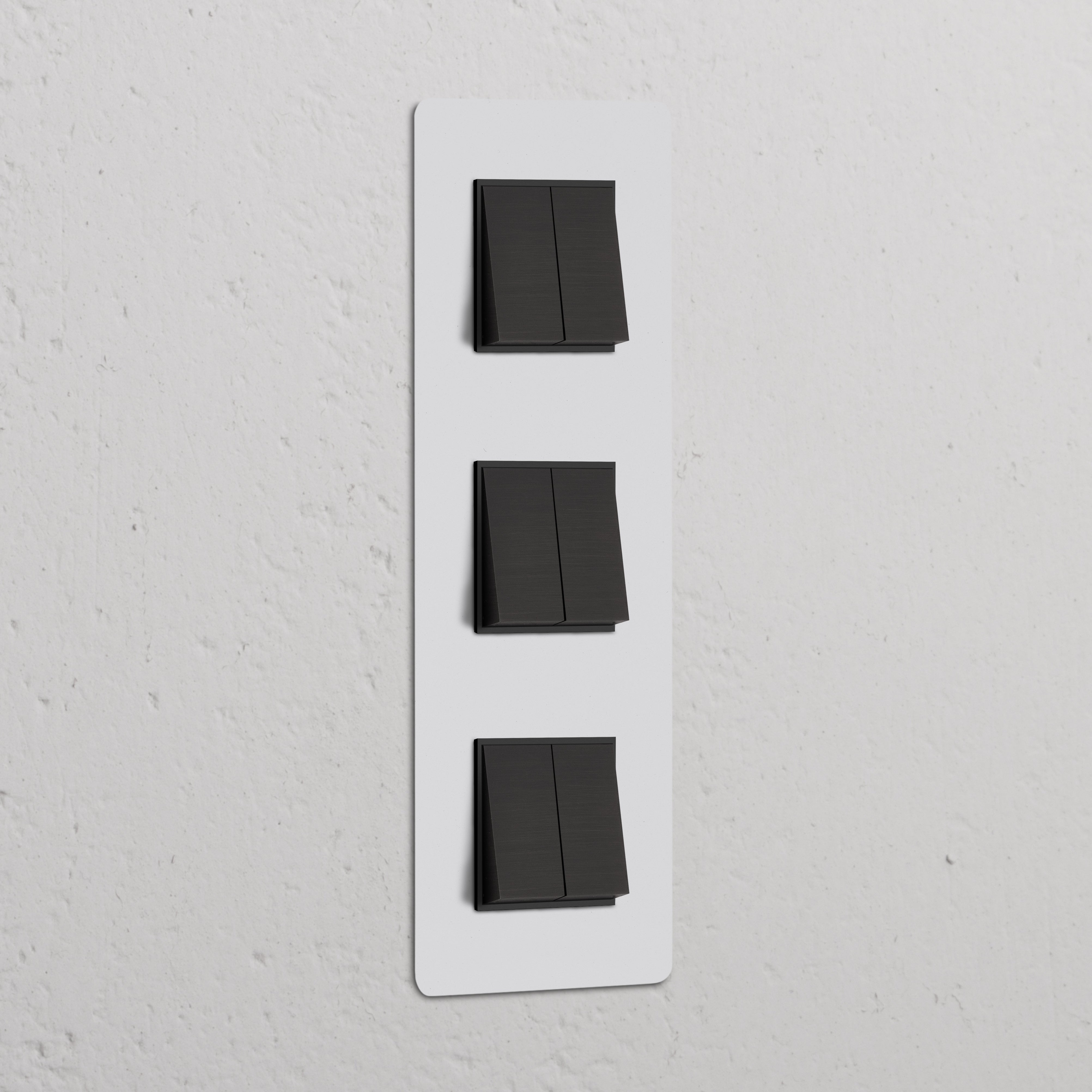 6x Wissel-Wipschakelaarset met een Drievoudige Verticale Afdekplaat in overschilderbaar brons op witte muur.