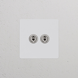 2x Wissel-Tuimelschakelaar in beschilderbaar gepolijst nikkel op een witte plaat voor enkele schakelaars & dimmers.