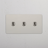 Veelzijdige Lichtschakelaar met drievoudige bediening: drievoudige tuimelschakelaar in Gepolijst Nikkel op witte achtergrond