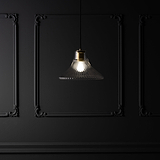 Suspension Hammersmith Moyen Format en Verre Cannelé avec finition laiton, élégamment exposée contre un mur en panneaux sombres.