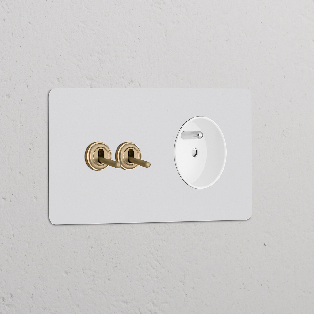 Interrupteur VV à levier x2 & Prise Type E sur double plaque laiton avec insert blanc, design classique mais moderne.