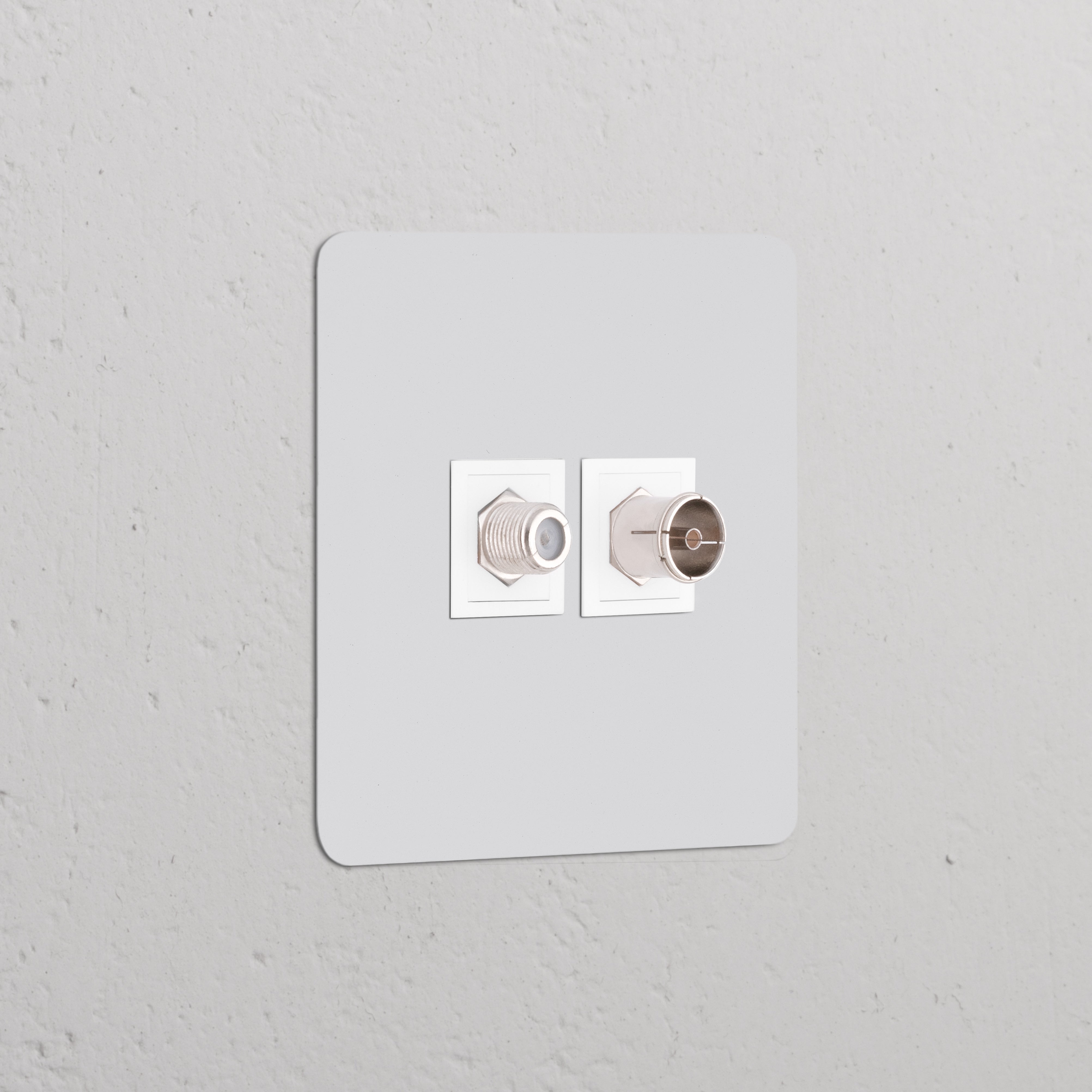 Prise Peignable Blanche Satellite & TV (Plaque Simple) montée sur un mur gris.