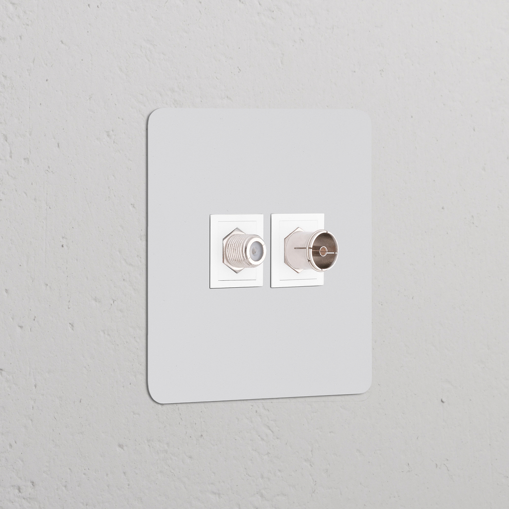 Prise Peignable Blanche Satellite & TV (Plaque Simple) montée sur un mur gris.