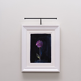 Un tableau de fleurs violettes éclairé par une lampe Harrow Picture Light 400 mm est élégamment accroché sur un mur sombre.