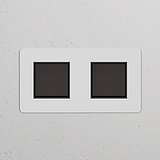 Interrupteurs doubles carrés en bronze avec insert noir sur plaque murale texturée blanche, Interrupteur VV Carré x2.