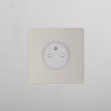 Prise de Courant Ronde Type E nickelée polie (Plaque Simple) avec insert blanc sur un mur propre.