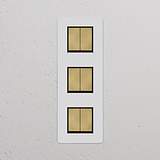 Interrupteur VV Carré x6 Vertical (Plaque Triple) - Laiton Ancien Peignable Insert Noir sur mur blanc.