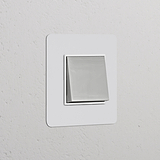 Interrupteur VV Carré avec finition Nickel Poli et insert Blanc sur mur texturé blanc, design épuré et moderne.