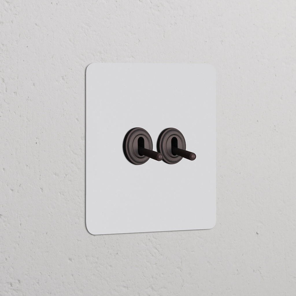 Interrupteur VV à Levier x2 (Plaque Simple) - Bronze Peignable sur un mur blanc, design classique et fonctionnel.