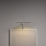 Harrow Bilderleuchte 220 mm in poliertem Nickel, eine elegante Bilderleuchte auf einem weißen Rahmen vor einer grauen Wand.