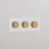 Dreifachrahmen mit 3x Mehrpunkt-Dimmerschalter, lackierbar, antikes Messing, horizontal angeordnet.