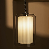 Pendelleuchte mit geripptem, zylindrischem Glasschirm, sanft schimmernde Beleuchtung.