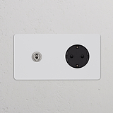 Zweifachrahmen mit Kipphebelschalter und Schuko Typ F, lackierbar, poliertes Nickel und Schwarz auf weißer Wand.