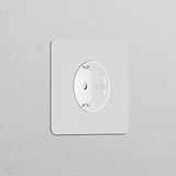 'Enchufe Schuko tipo F redondo con inserto blanco, pintable para una integración perfecta en configuraciones de marcos individuales.'