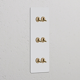 Interruptor de palanca vertical de triple marco, acabado en latón antiguo, pintable. Adecuado para configuraciones de control de iluminación verticales.
