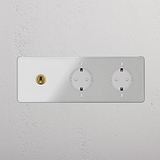 Panel de triple marco con interruptor de palanca redondo y bases Schuko x2, acabado latón antiguo y transparente, inserto blanco.