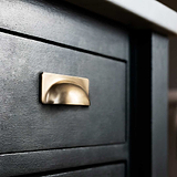 Tirador concha Elm en latón antiguo sobre mueble negro