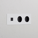 Módulo redondo USB 30W + Schuko x2 tomas en marco triple con inserto negro pintable para decoración personalizable.