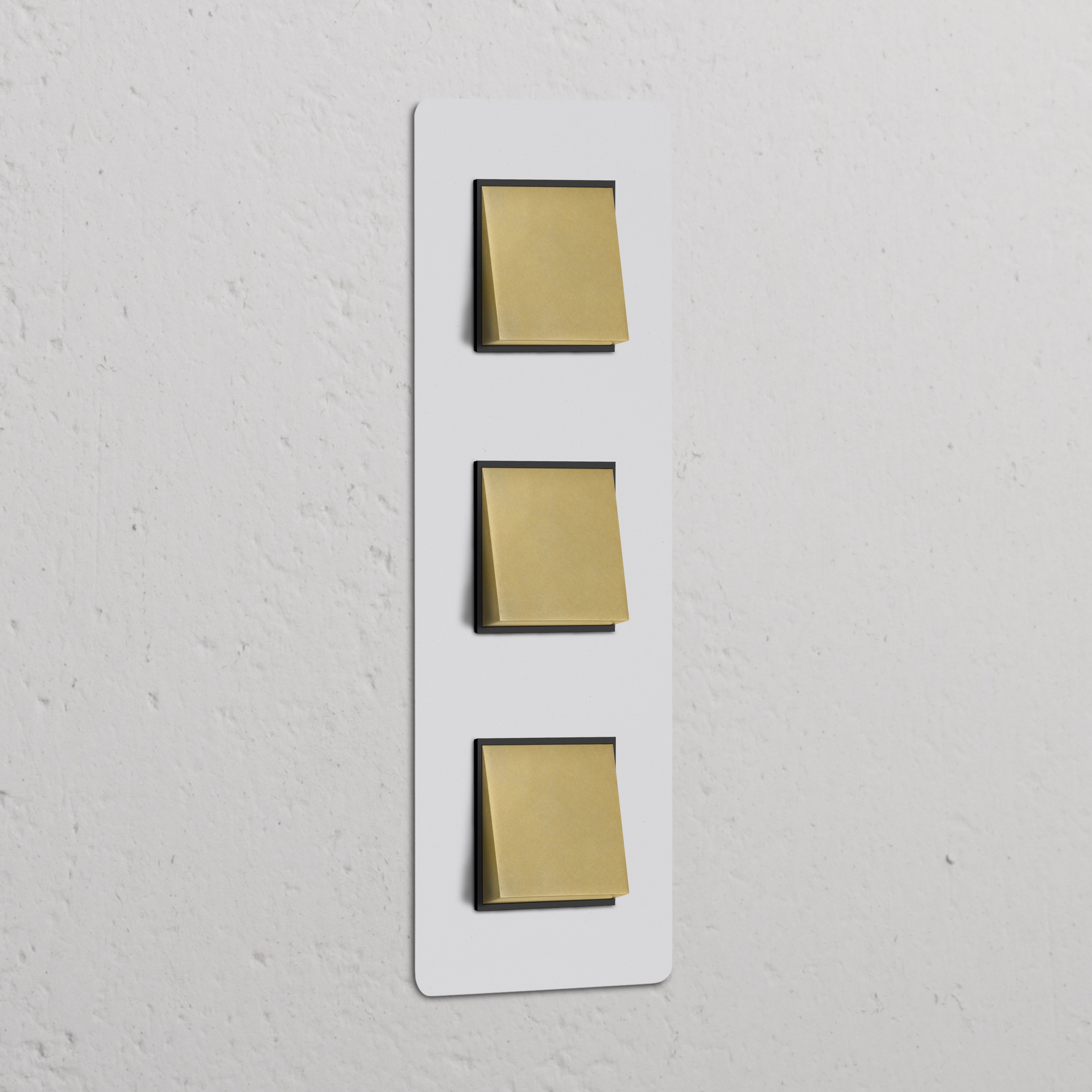 Panel de interruptores basculantes triples verticales con marco pintable y acabado en latón antiguo, inserto negro.