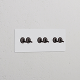 Interruptor conmutador de palanca x6 (marco triple) - Pintable y bronce; interruptores en marco triple.