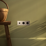 Tomas de pared de triple marco en níquel pulido con módulo USB redondo y Schuko x2 sobre una superficie elegante.