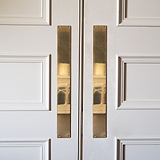 Placa de empuje de puerta Harper de latón antiguo, 580 mm, sobre puertas dobles blancas para un toque elegante.