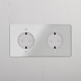 Módulo Schuko x2 redondo de doble marco con marco transparente e inserto blanco, dotado de dos bases eléctricas.