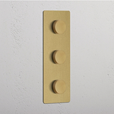 Plaque triple verticale en laiton ancien avec trois variateurs multidirectionnels ronds alignés.