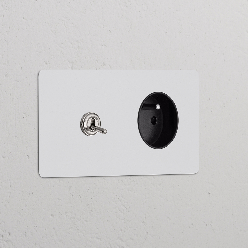 Interrupteur double nickelé et prise ronde Type E, insert noir, style levier sur double plaque.