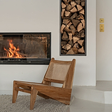 Interrupteur à bascule simple en Laiton Ancien fixé au mur au-dessus d'un interrupteur à bascule double en Laiton Ancien. A gauche, une cheminée encastrée à cadre noir avec une étagère murale encastrée à cadre noir stockant du bois de chauffage et une chaise en bois en dessous.