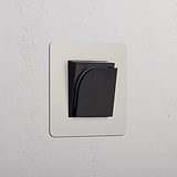 Lecteur de carte Nickel Poli (Insert Noir) pour hôtel - prise simple à plaque sur un mur blanc texturé.