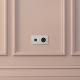 Plaque double Nickel Poli avec prise ronde noire USB-C 30W et Type E sur un mur rose clair.