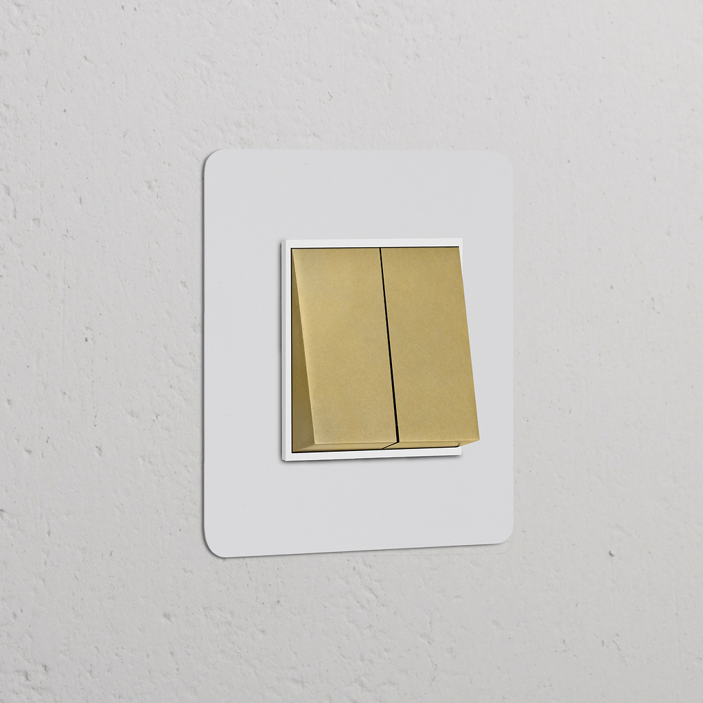 Interrupteur VV Carré x2 en Laiton Antique avec Insert Blanc sur une plaque simple contre un mur blanc.