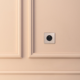 Prise de Courant Ronde Type E (Plaque Simple) en Nickel Poli élégant avec insert noir sur une paroi beige.