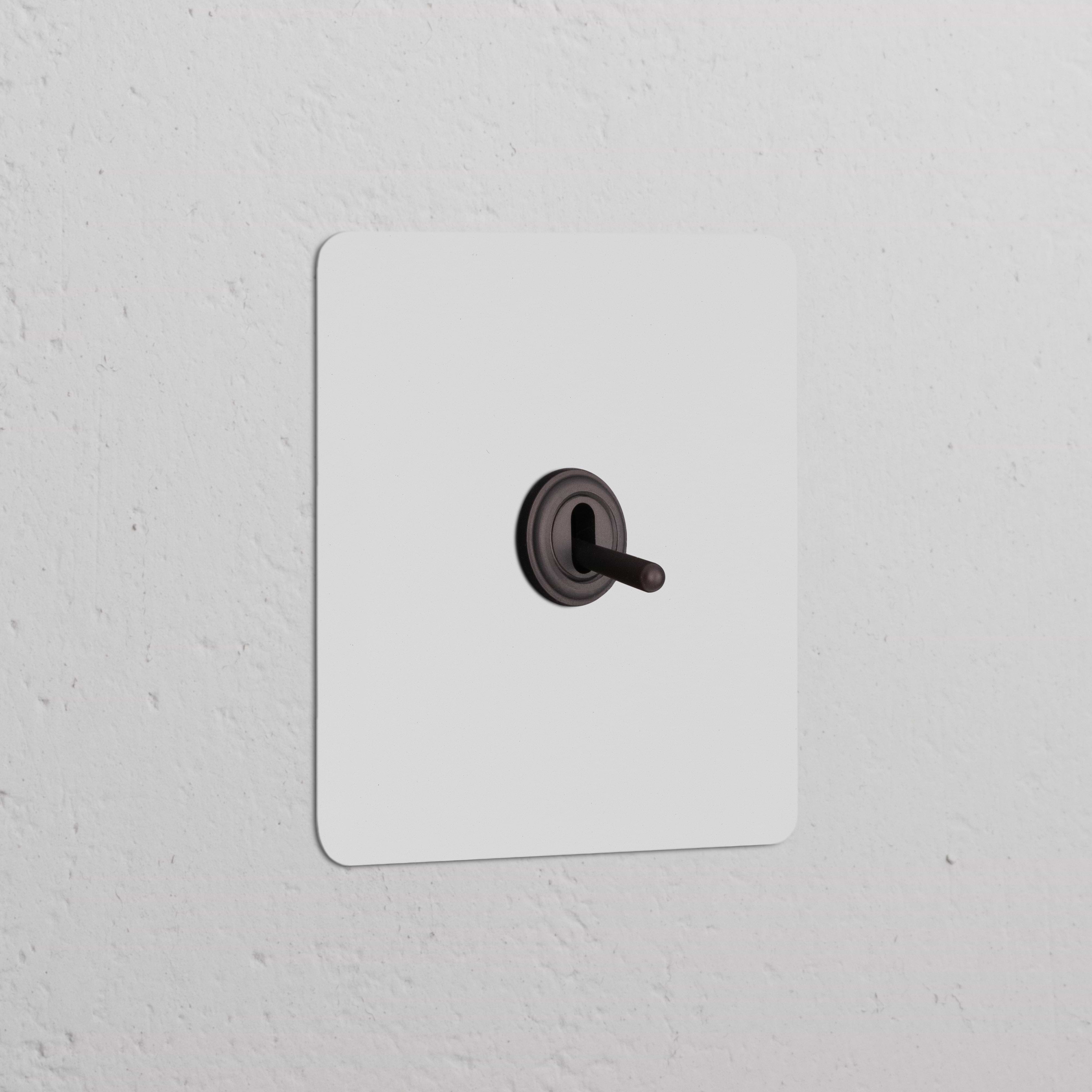 Interruttore a Levetta Singolo verniciabile in bronzo su placca da parete bianca elegante.