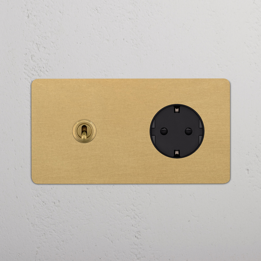Doppio Modulo Levetta & Schuko Tondo in Ottone Antico Nero, combina elegantemente doppia presa e interruttore a levetta.