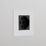 Modulo spina Schuko/Bipasso Nero Verniciabile Nero su parete bianca testurizzata, per prese elettriche singole.