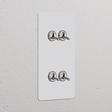 Interruttore a levetta doppio verticale, 4x, con finitura nichel lucido; design verniciabile.