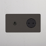 Bronzo Nero Doppio Modulo Levetta e presa Schuko Tondo su parete bianca, evidenziandone il design elegante.