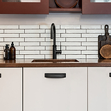 Mobili color crema con maniglie in olmo Maniglia Conchiglia da 164 mm - Bronzo, abbinati a un rubinetto nero e piastrelle della metropolitana.