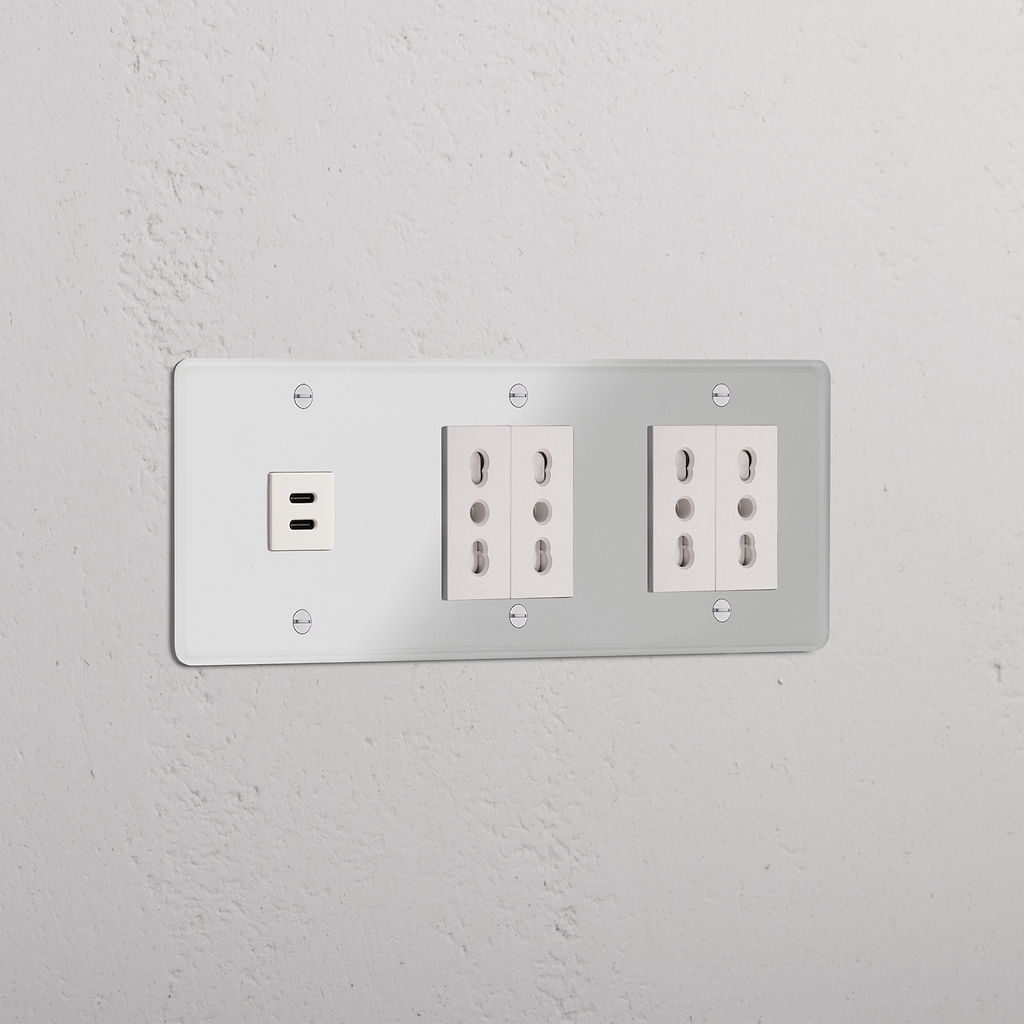 Tripla Presa e Moduli in Trasparente Bianco con Modulo Triplo USB 30W e 4 prese Bipasso su parete bianca.