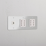 Tripla Presa e Moduli in Trasparente Bianco con Modulo Triplo USB 30W e 4 prese Bipasso su parete bianca.