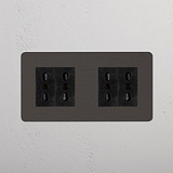 Presa di corrente Modulo Doppio 4x Bipasso - Bronzo Nero su parete bianca, ideale per le esigenze Doppie Prese & Moduli.