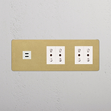 Modulo USB triplo e 4 prese Bipasso in finitura Ottone Antico Bianco su pannello bianco testurizzato.